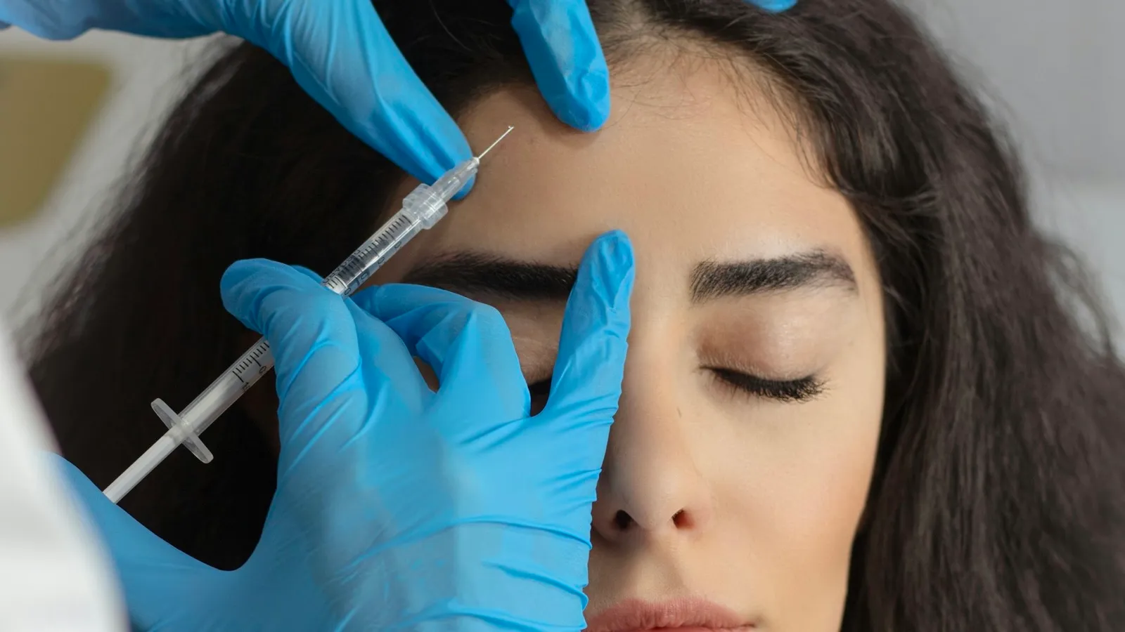 Provider treating forehead lines with a fine-needle injection