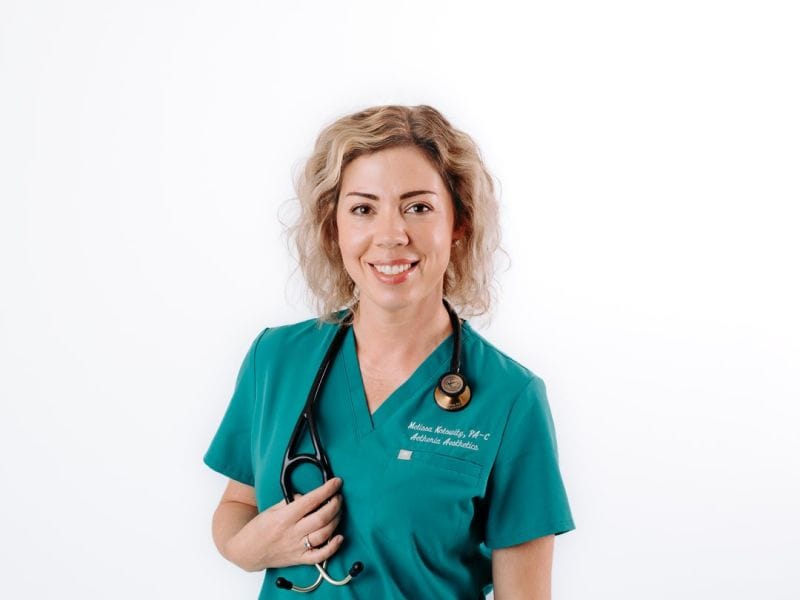 Aetheria Aesthetics & Wellness founder Melissa Kolowitz PA-C smiling in teal scrubs.